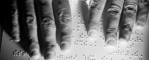 twee handen op een pagina met braille